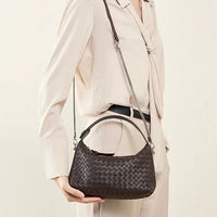 Woman in beige suit holding a dark brown woven leather shoulder bag