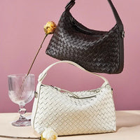 Black and white woven leather handbags with flowers on a pink background
