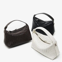 Three woven leather handbags in black, brown, and white on a white background