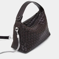 Dark brown woven leather handbag with top handle and silver chain strap on white background