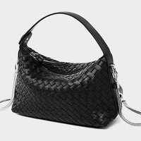 Black woven leather handbag with silver hardware on a light background