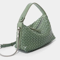 Sage green woven leather handbag with top handle and silver chain strap on white background