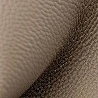 Close-up of beige pebbled leather texture with natural grain folds, luxury upholstery material