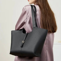 Woman wearing a black leather tote bag over shoulder, with lavender satin blouse