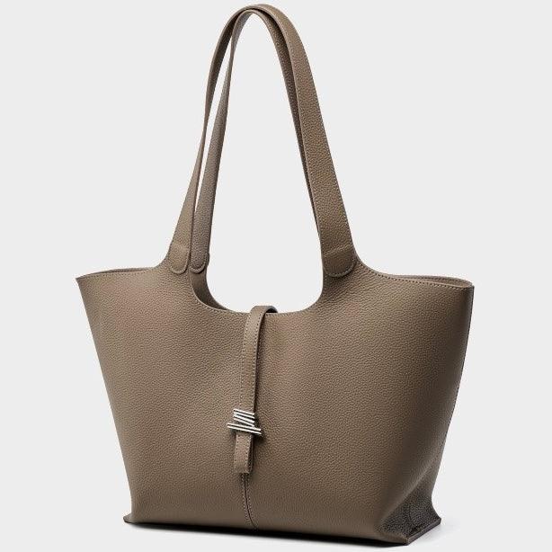 Taupe leather tote bag with double handles and silver clasp on a light background