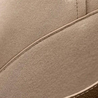 Close-up of beige suede shoe with visible stitching and textured material