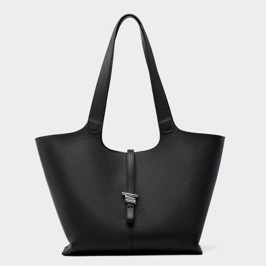 Black leather tote bag with metal detail and long handles on a plain background