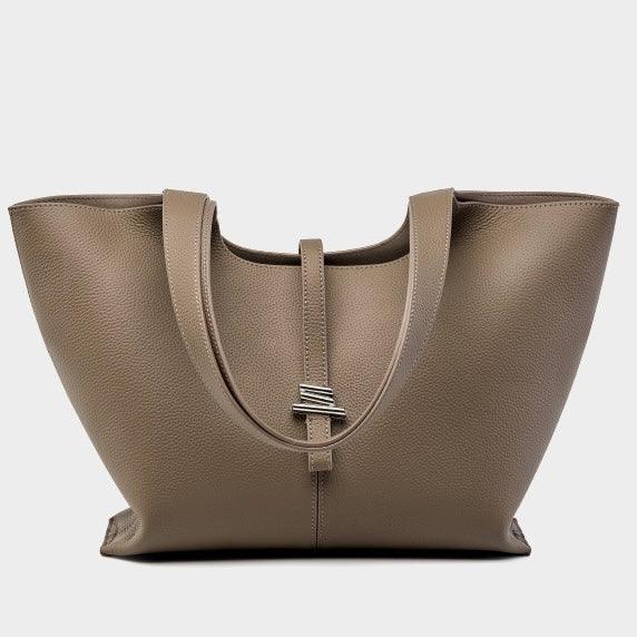 Taupe leather tote bag with double handles and silver buckle, isolated on white background