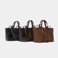 Three leather tote bags in black, dark brown, and brown on a white background