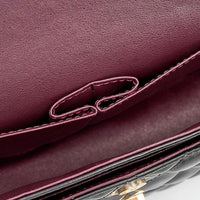 Close-up of quilted leather purse interior with burgundy lining and stitched pocket