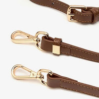 Brown faux leather adjustable bag strap with gold clasp hardware on white background