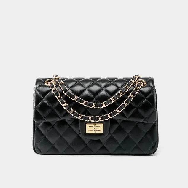 Black quilted leather handbag with gold chain strap and turn-lock clasp on white background