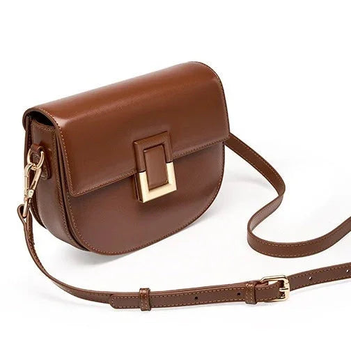 Brown leather crossbody bag with gold buckle on white background