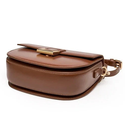 Brown leather crossbody bag with gold clasp on white background