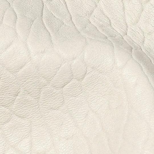 Close-up of textured cream white leather surface with natural grain pattern