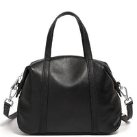 Black leather handbag with top handles and detachable shoulder strap on white background