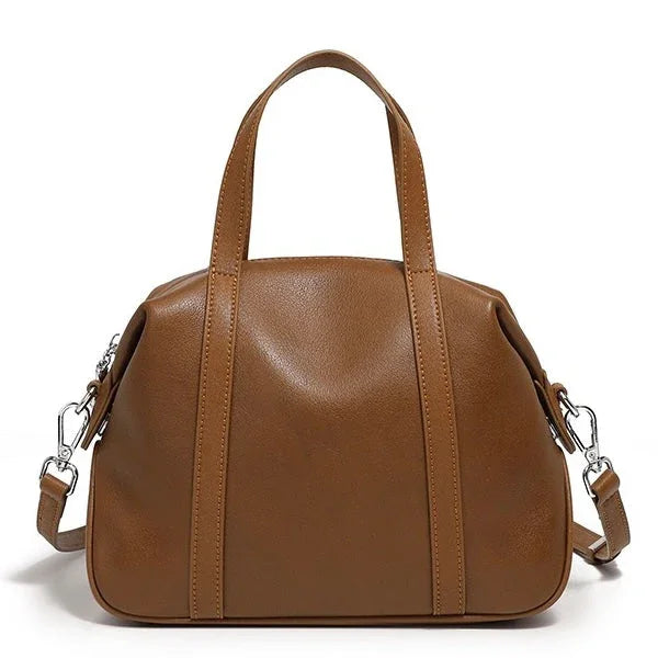Brown leather handbag with double handles and detachable shoulder strap on white background