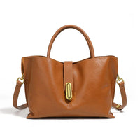 Brown leather handbag with gold hardware, top handle and shoulder strap on white background
