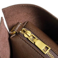 Closeup of brown leather bag with gold zipper and suede lining