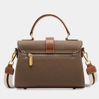 Taupe leather handbag with gold zipper, brown top handle, and striped shoulder strap