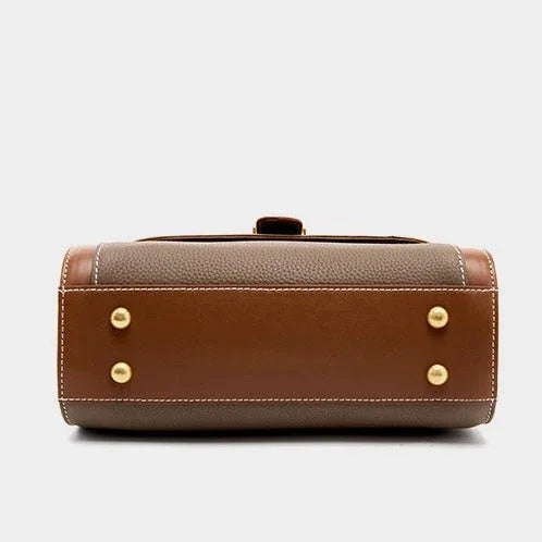 Brown leather handbag base with gold feet and white stitching on a plain background