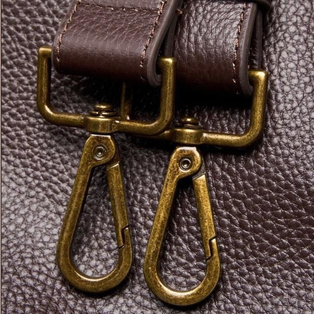 Close-up of brown leather bag with brass clasps and textured leather surface