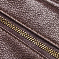 Close-up of brown textured leather with brass zipper, leather bag material detail