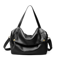 Black leather tote bag with gold accents and shoulder strap on white background