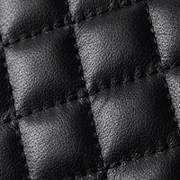 Close-up of quilted black leather texture with square stitching, luxury material detail