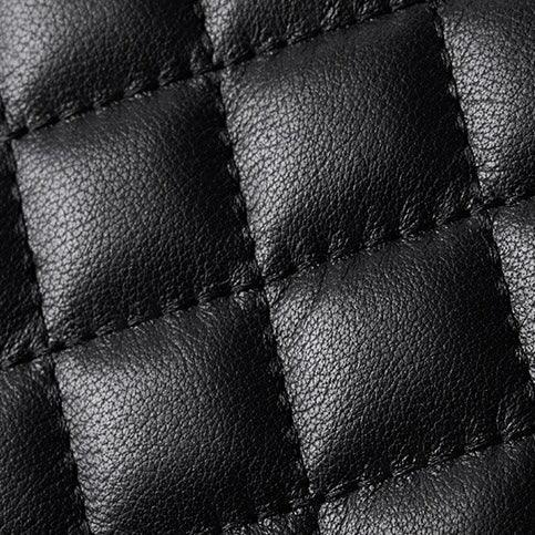 Close-up of quilted black leather texture with square stitching, luxury material detail