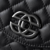 Black quilted leather handbag with shiny silver interlocking clasp close-up