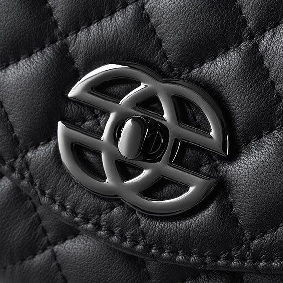 Black quilted leather handbag with shiny silver interlocking clasp close-up