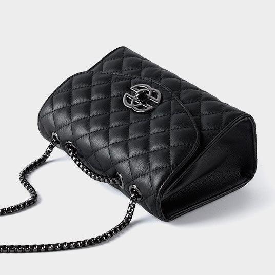 Black quilted leather handbag with chain strap on light background