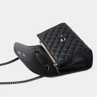 Black quilted leather shoulder bag with chain strap, open on white background