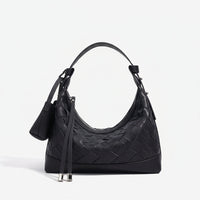 Black woven leather shoulder bag with curved handle and silver accents on white background