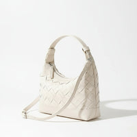 White woven leather crossbody bag with zipper on light surface