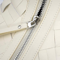 Close-up of cream woven leather handbag with silver zipper detail