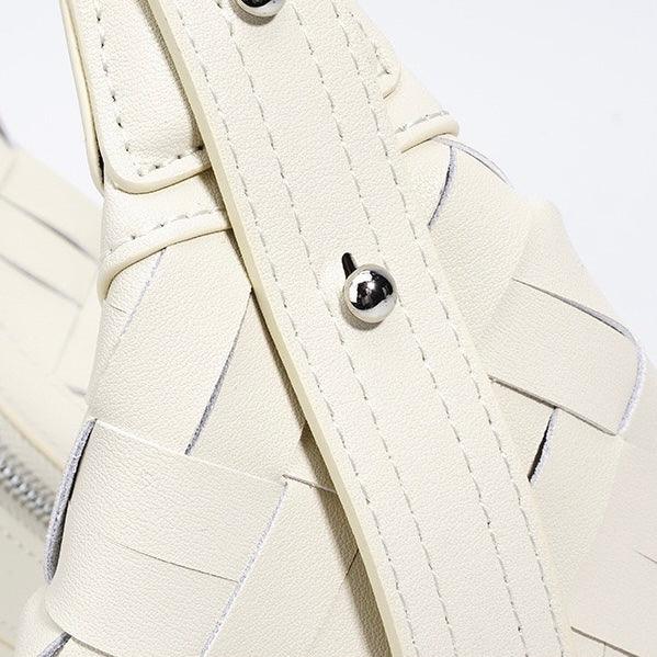 Close-up of cream woven leather sandal strap with silver buckle detail