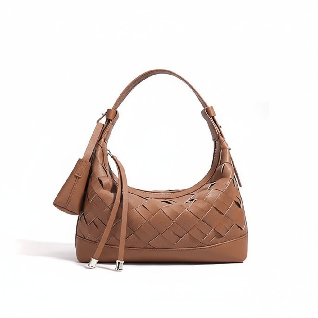 Brown woven leather shoulder bag with top handle, tassel details, on white background