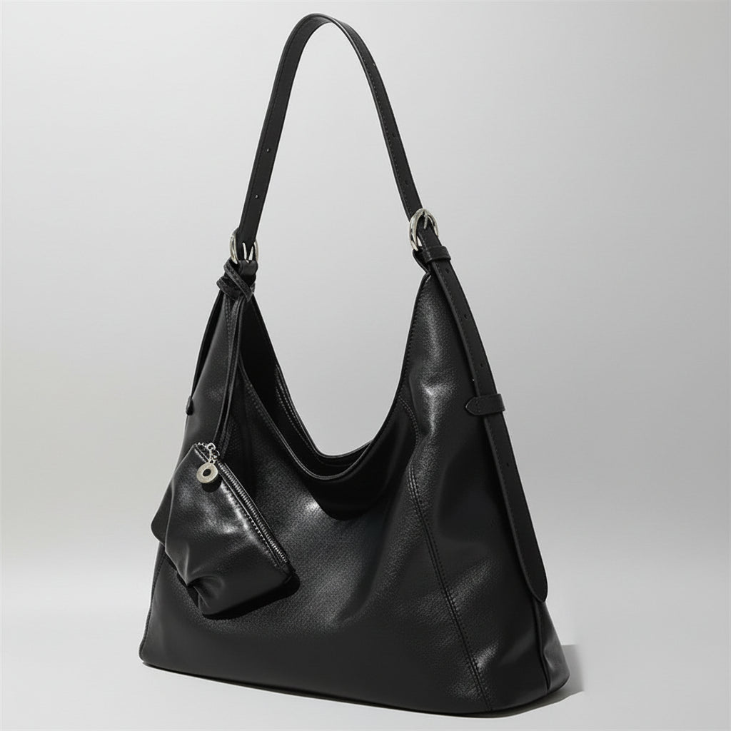 Black leather shoulder bag with small matching pouch on a neutral background