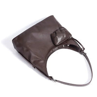 Brown leather shoulder bag with adjustable strap and attached small pouch on white background