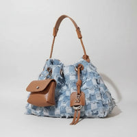 Blue checkered denim handbag with brown leather handle and pouch, fashion accessory