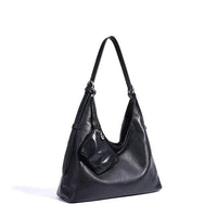 Black leather shoulder bag with attached coin purse on white background
