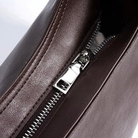 Close-up of brown leather bag with silver zipper