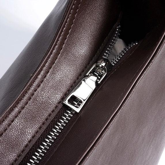 Close-up of brown leather bag with silver zipper