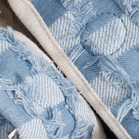 Closeup of blue and white denim patchwork slippers with frayed edges