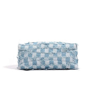 Light blue checkered denim clutch bag with frayed edges on white background