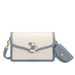 Blue and white crossbody bag with bunny charm and gold hardware on white background