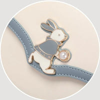 Cute bunny enamel pin with pearl on cream and blue handbag