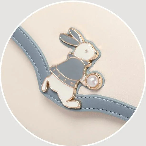 Cute bunny enamel pin with pearl on cream and blue handbag